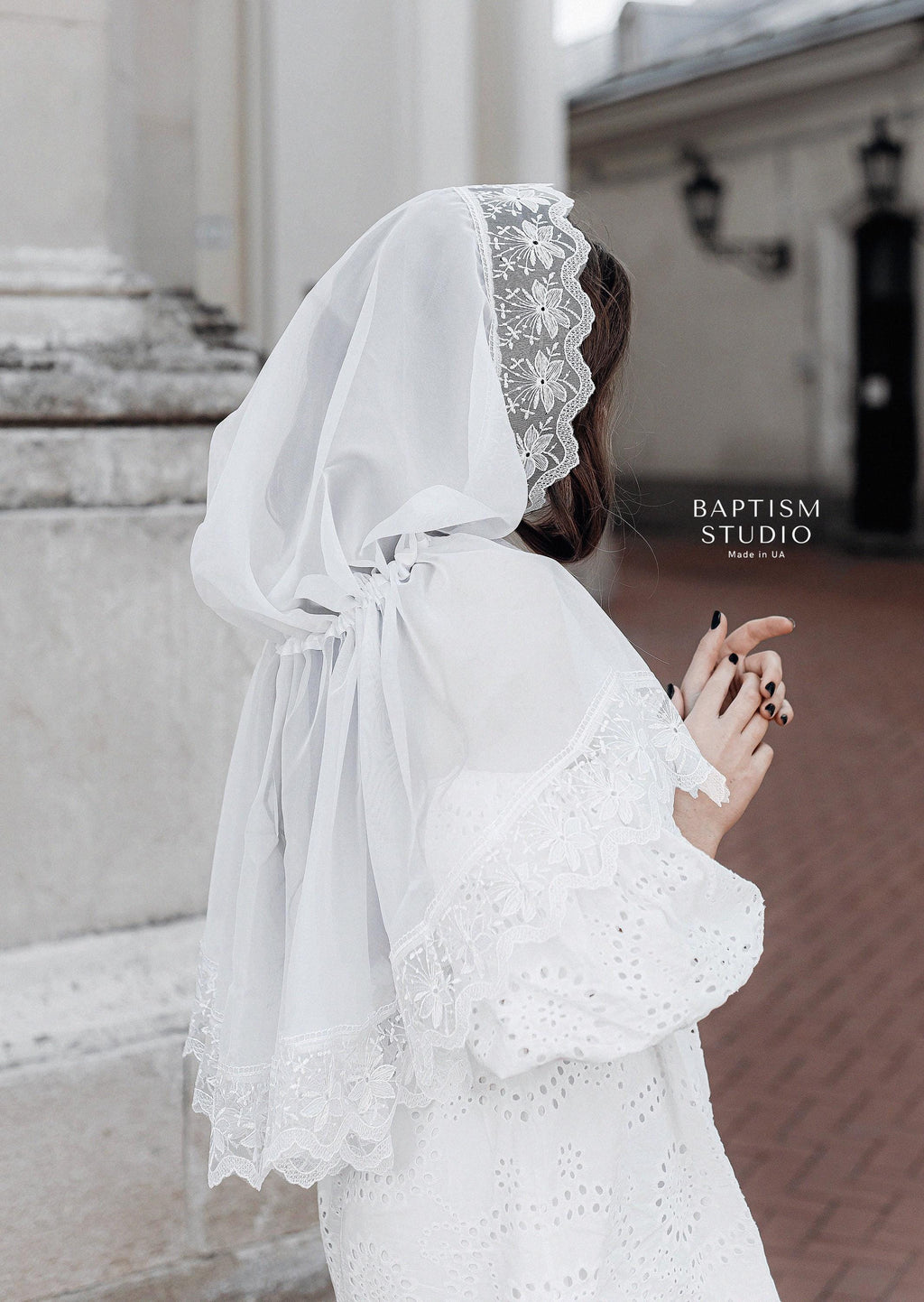 Woman wearing a white lace chapel veil, lightweight tulle church head covering with floral lace edging