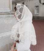 Woman wearing white lace church palantine, lightweight tulle prayer shawl covering head and shoulders
